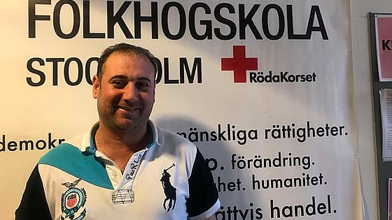 Man framför skylt på Röda Korsets Folkhögskola