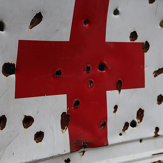 Karossen på en sönderskjuten ambulans med rött kors.