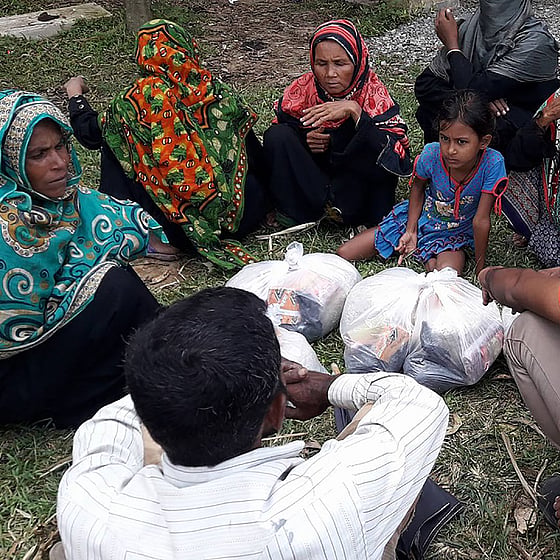 Volontär och kvinnor i Cox's Bazar sitter i cirkel