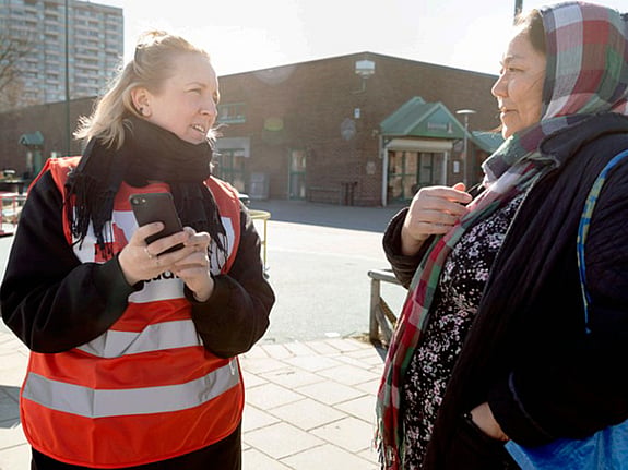 Två kvinnor pratar i motljus