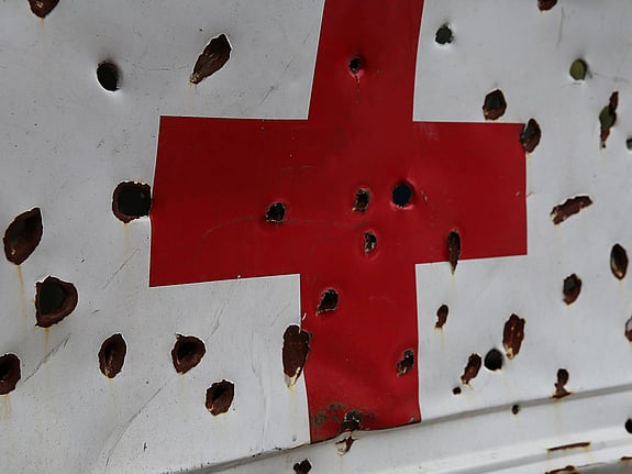 Karossen på en sönderskjuten ambulans med rött kors.