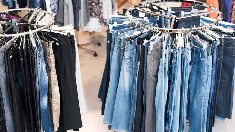 jeans-som-hänger-på-klädstång-i-butiken