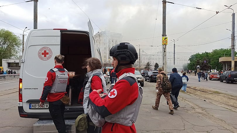 Tre volontärer från Röda Korset står vid en skåpbil och förbereder assistans åt drabbade i Dnipro.