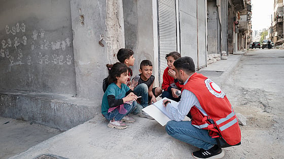 Volontär samtalar med barn i Syrien