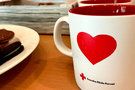 En kopp kaffe står på ett bord tillsammans med kakor.
