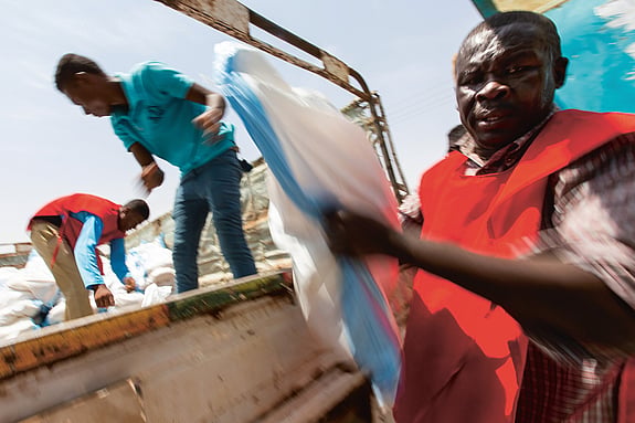 Volontär delar ut mat i Sudan